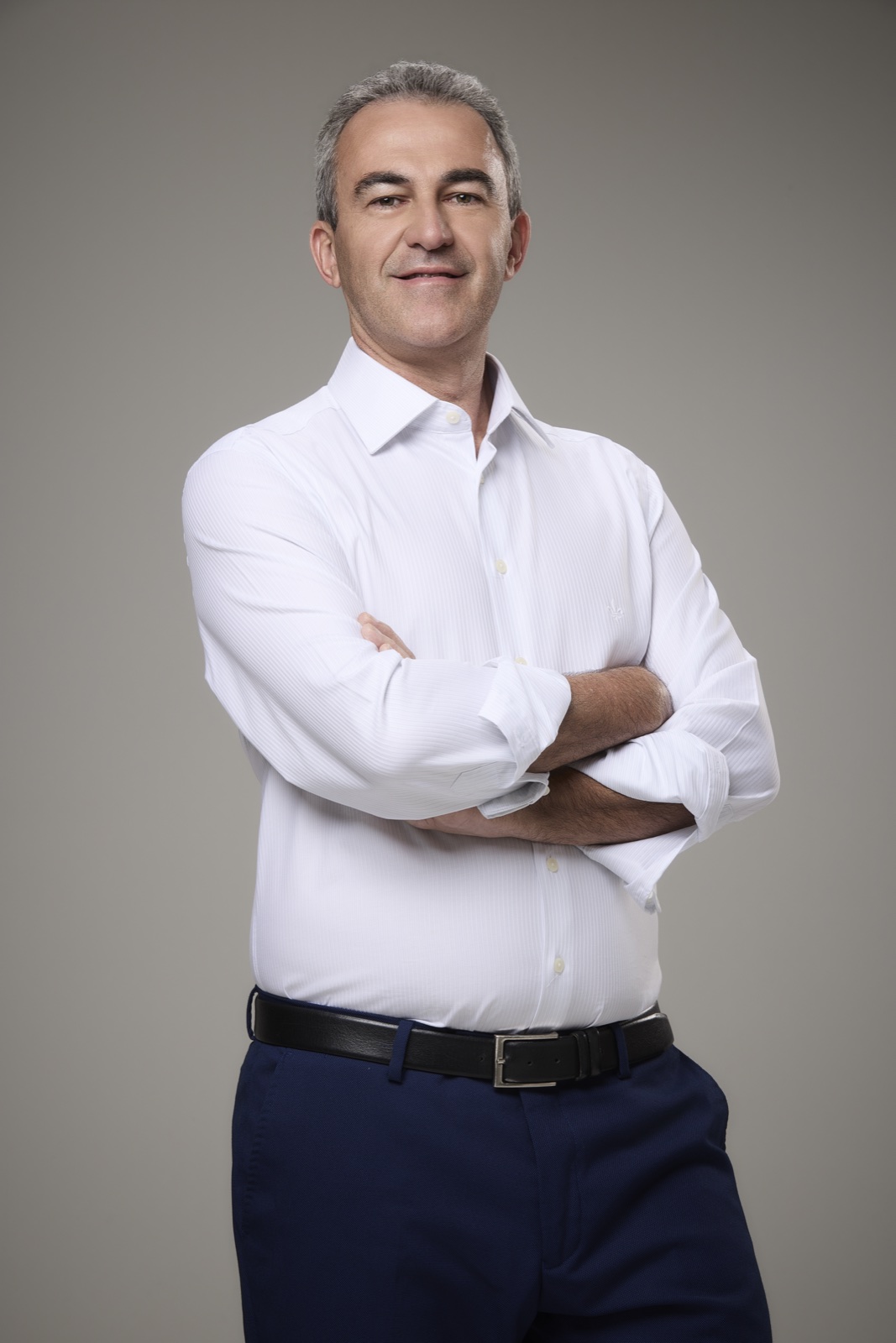 Renato Archanjo de Castro, engenheiro eletricista, de camisa branca, em pé com os braços cruzados.
